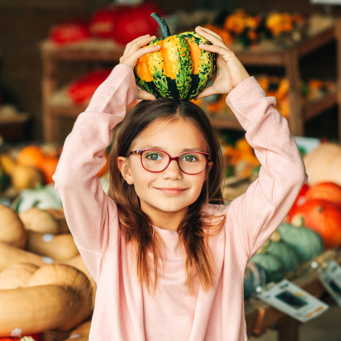 Adorable girl selecting her fall pumpkins at a local farm market.